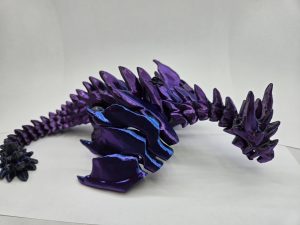 Articulated wyvern. Poseable neck,wings and legs. Made from silk dual or tri color PLA filament. 